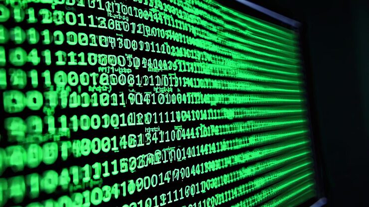 Photo green lines of binary code scroll down a computer screen creating a visual representation of complex data processing and programming languages