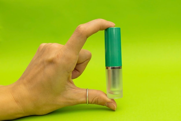 Green lipstick on green background monochrome