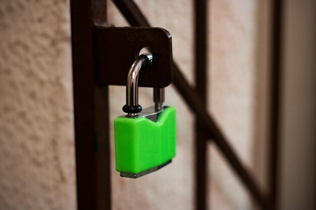 Green lock on a metal grill close up