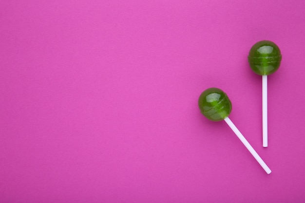 Green lollipops on pink . sweet candy concept