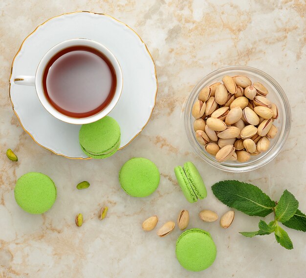 Green macaron with a cup of tea