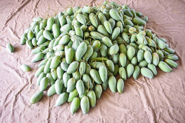 Photo green mango for sale in the fruit market in thailand - fresh raw mango harvest from tree agriculture asian