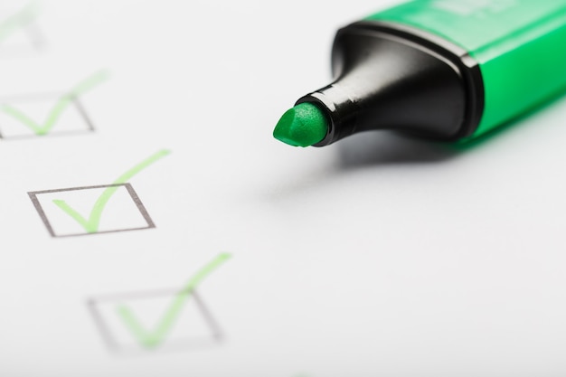 Зеленый маркер с маркерами на листе контрольного списка. Контрольный список завершил концепцию задачи.