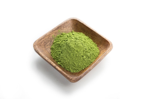 Green matcha powder on a wooden plate on white background Green matcha powder isolated on white