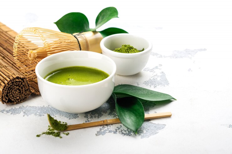 緑の抹茶茶飲料と白い背景の上の茶アクセサリー