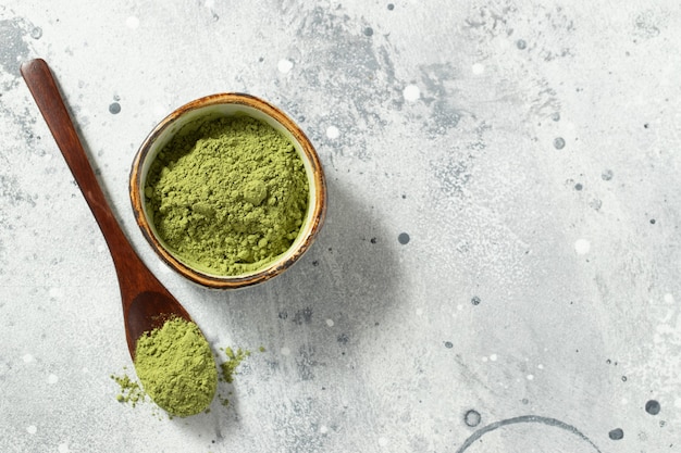 Green matcha tea powder with spoon.