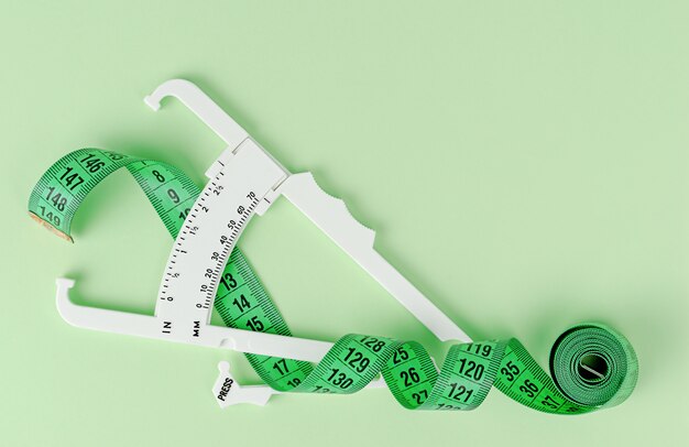 Green measuring tape and white caliper.