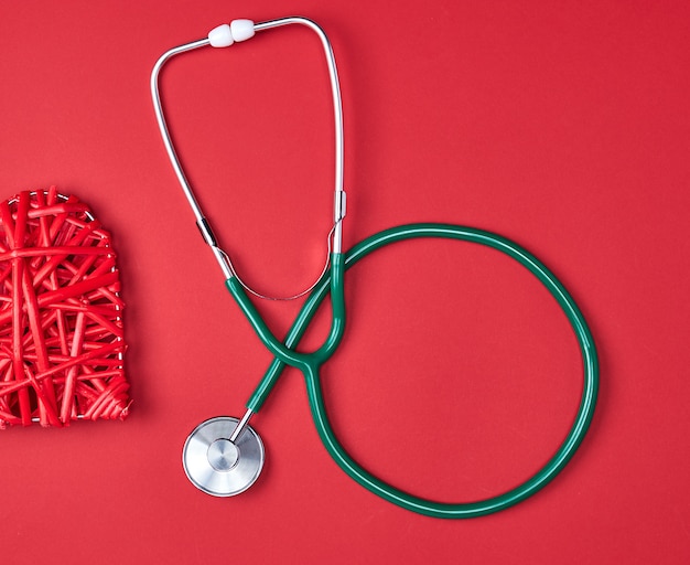 Green medical stethoscope  on red 