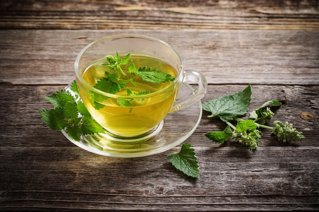 Photo green melissa herbal tea in glass cup on wooden space