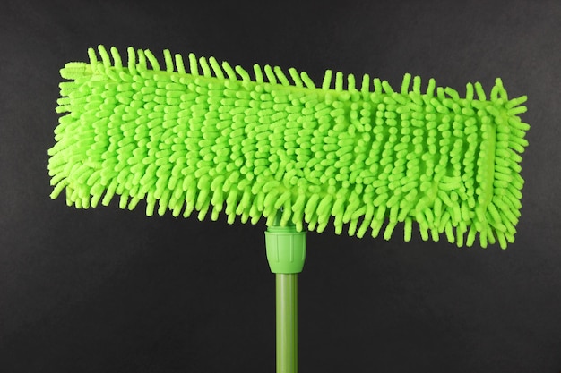 Green mop for floor on gray background