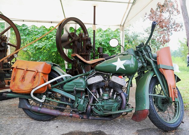 Photo green motorcycle with leather bag and star shape by machinery