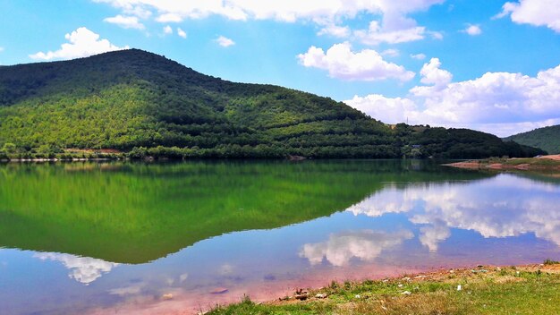 Green mountain reflecting on calm gracanica lake