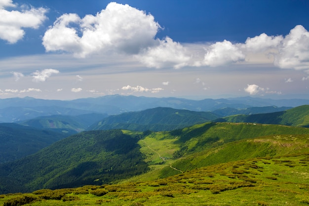 Green mountains panorama under blue sky on bright sunny day. Tourism and traveling concept, copy space