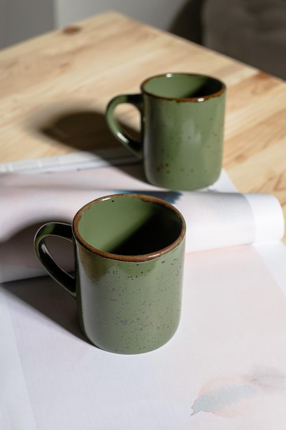 Green mugs on the desktop with a magazine