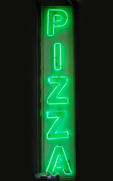 Фото Зеленый неоновый световой знак пиццы, обозначающий пиццерию