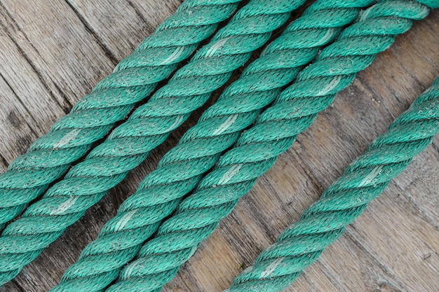 Фото Зеленая нейлоновая шпагат - старая веревка на деревянном фоне