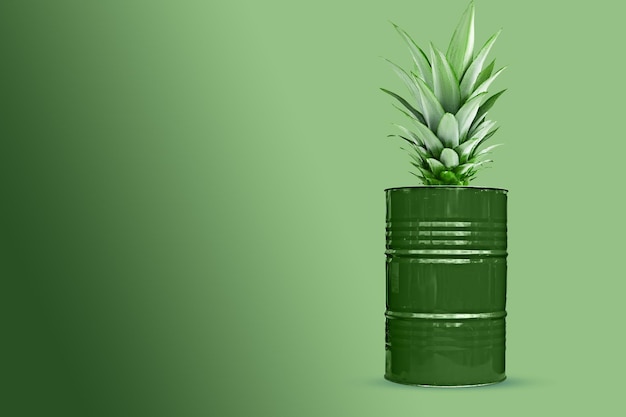 Photo green oil barrel with pineapple leaves on green background