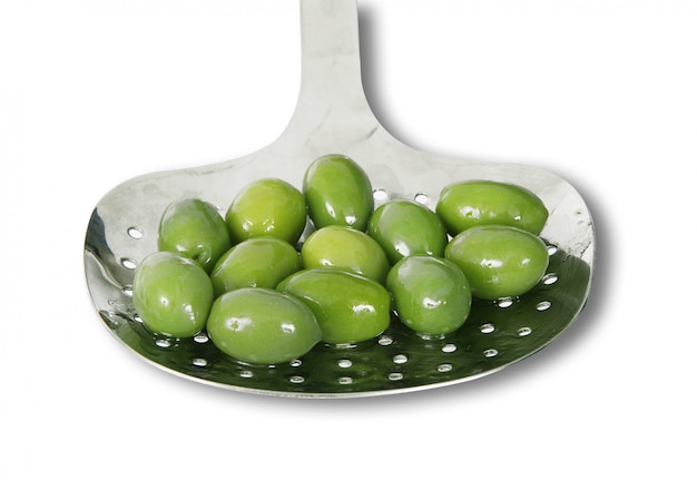 Green olive in ladle in white