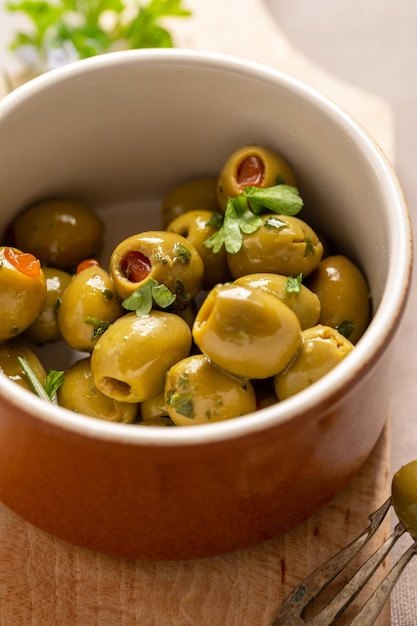 Green olives in a bowl Delicious marinated olives Top view