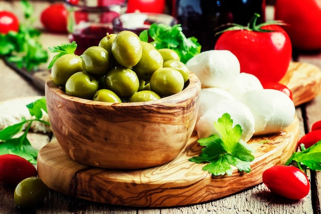 Green olives cheese tomatoes and wine still life selective focus