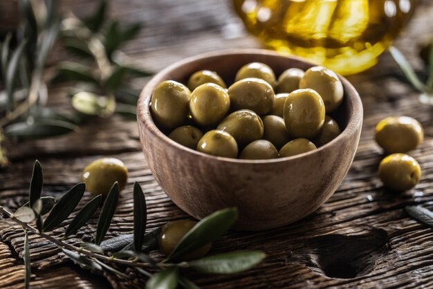 Green olives from mediterranean are served in wooden bowl