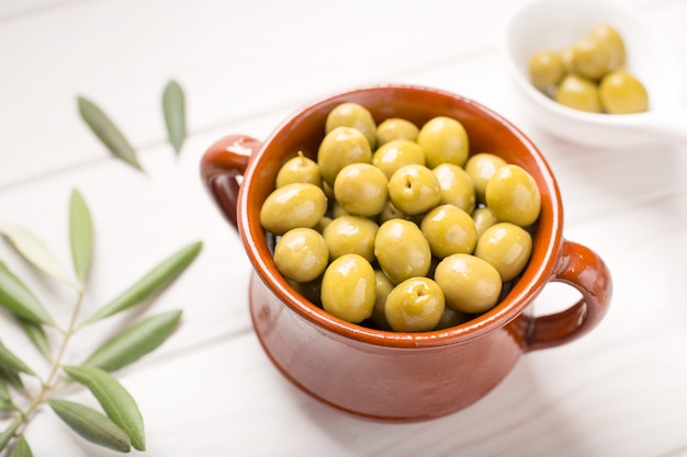 Green olives on rustic bowl