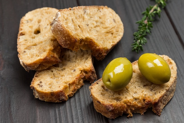 Green olives and slices of bread. Close up.
