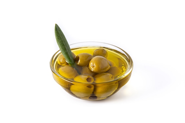 Green olives in a transparent bowl isolated on white background