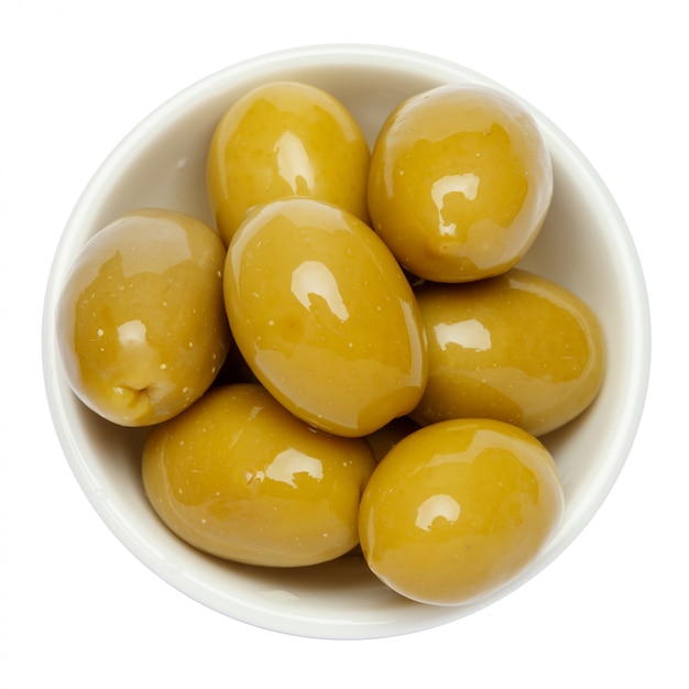 Green olives in white bowl on white table