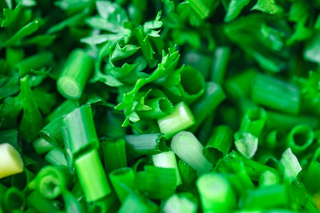 Фото Зеленый лук и петрушка свежие, нарезанные в большом количестве, с выборочной фокусировкой