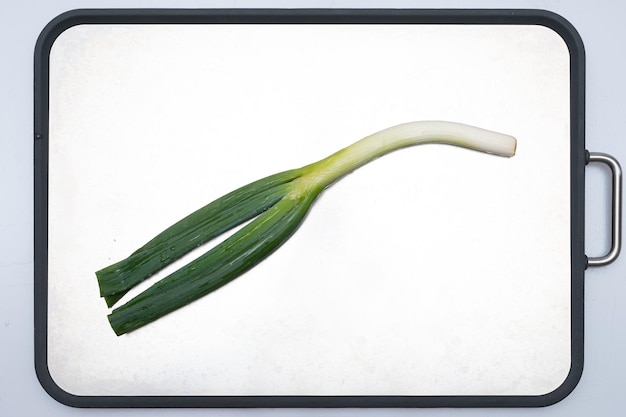 Green onion being trimmed on a white background