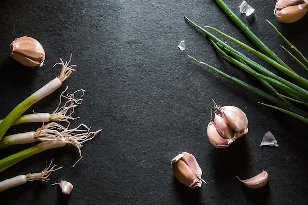 Green onions and garlic on the right and left on the table