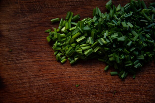 The green onions is cut on wooden background.