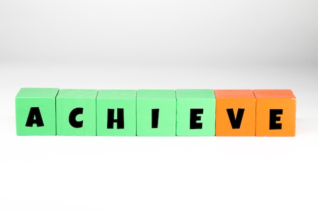 A green and orange cube with the word ACHIEVE on it