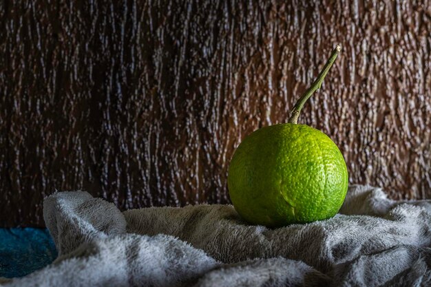 Green orange fruit on a brown background