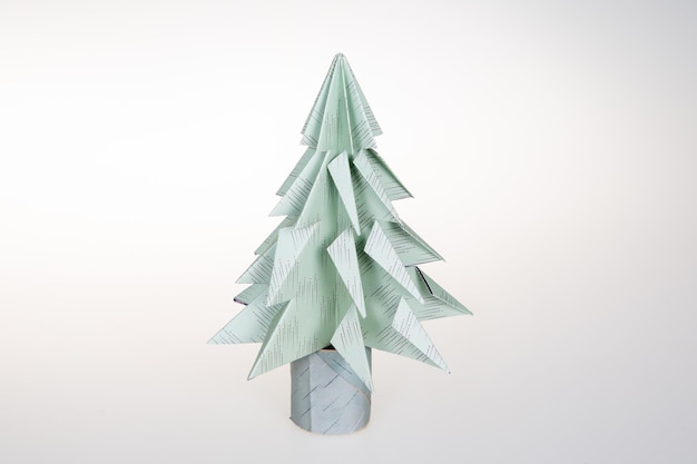 Green origami Christmas tree paper on white background decoration with design paper for Happy New Year