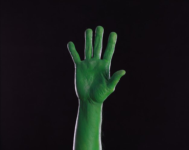 Photo green painted hands on black background