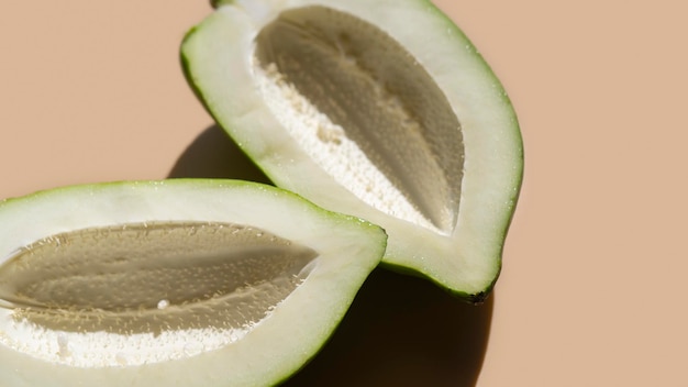 Green papaya on beige background