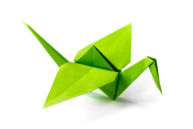 Origami di gru di carta verde isolato su sfondo bianco