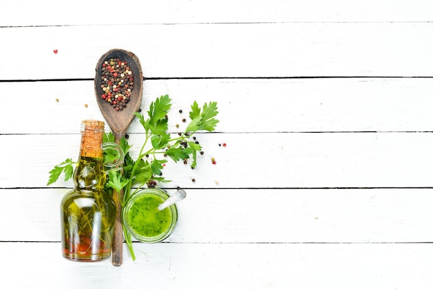 Foto salsa di prezzemolo verde ingredienti per salsa chimichurri su uno sfondo di legno bianco vista dall'alto spazio libero per il testo
