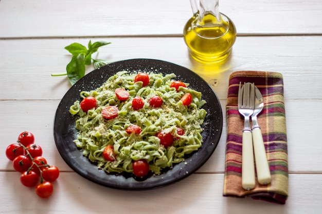 Green pasta with tomatoes and parmesan cheese. White  . Top view.