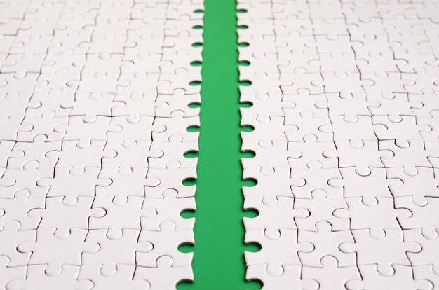 The green path is laid on the platform of a white folded jigsaw puzzle