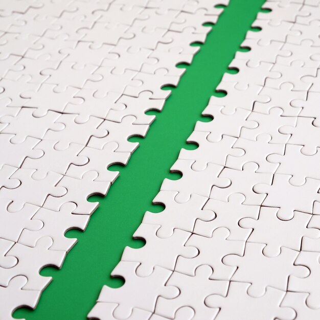 The green path is laid on the platform of a white folded jigsaw puzzle