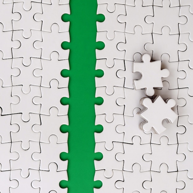 The green path is laid on the platform of a white folded jigsaw puzzle. 