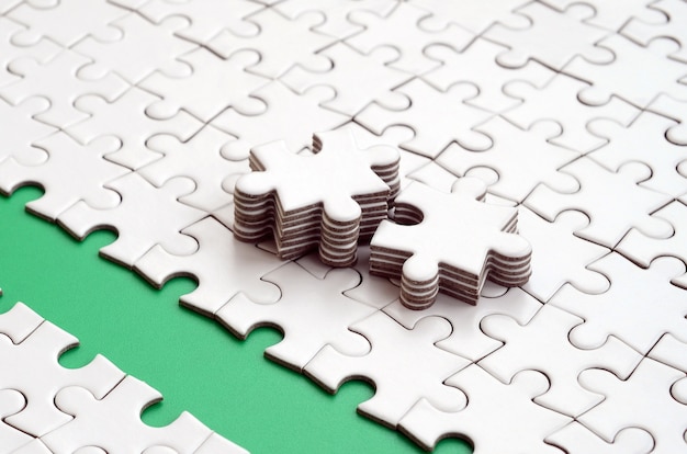 The green path is laid on the platform of a white folded jigsaw puzzle. 