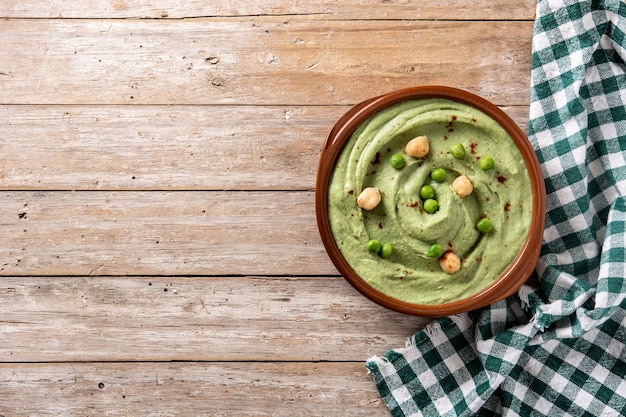 Green pea hummus and pita bread on wooden table