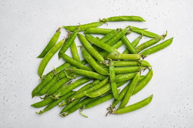 Green pea pod on gray stone table background top view flat lay