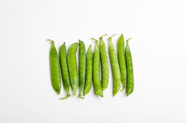 green pea pod, green peas, white surface