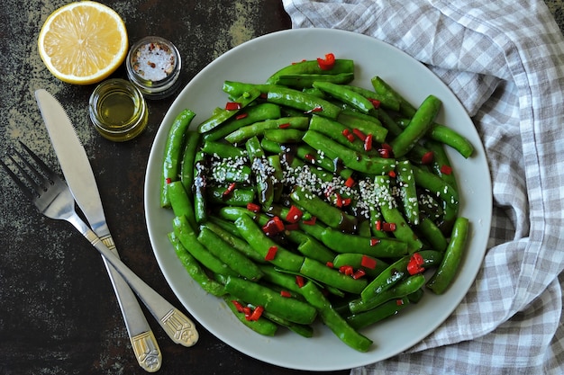 Green pea pods with chilli and sesame. Green pods in Chinese style.