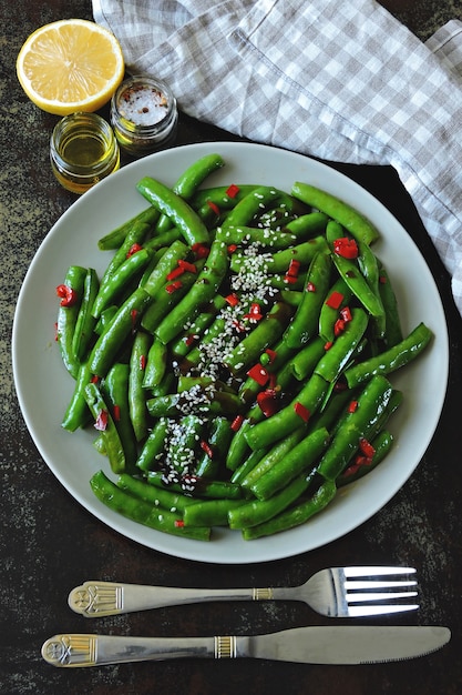 緑色のエンドウ豆の鞘に唐辛子とゴマ。中華風の緑のさや。